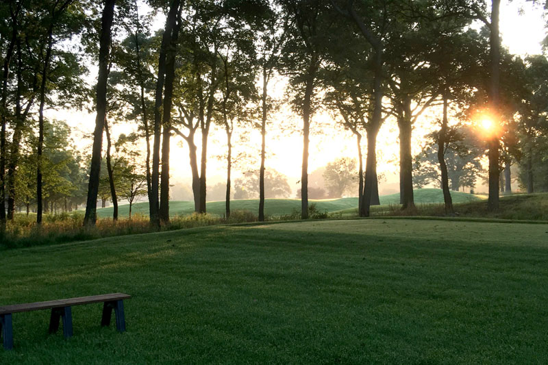 ArrowHead Golf Course during sun set with trees and a bench