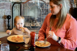 Mother and child eating nuggets and fries together