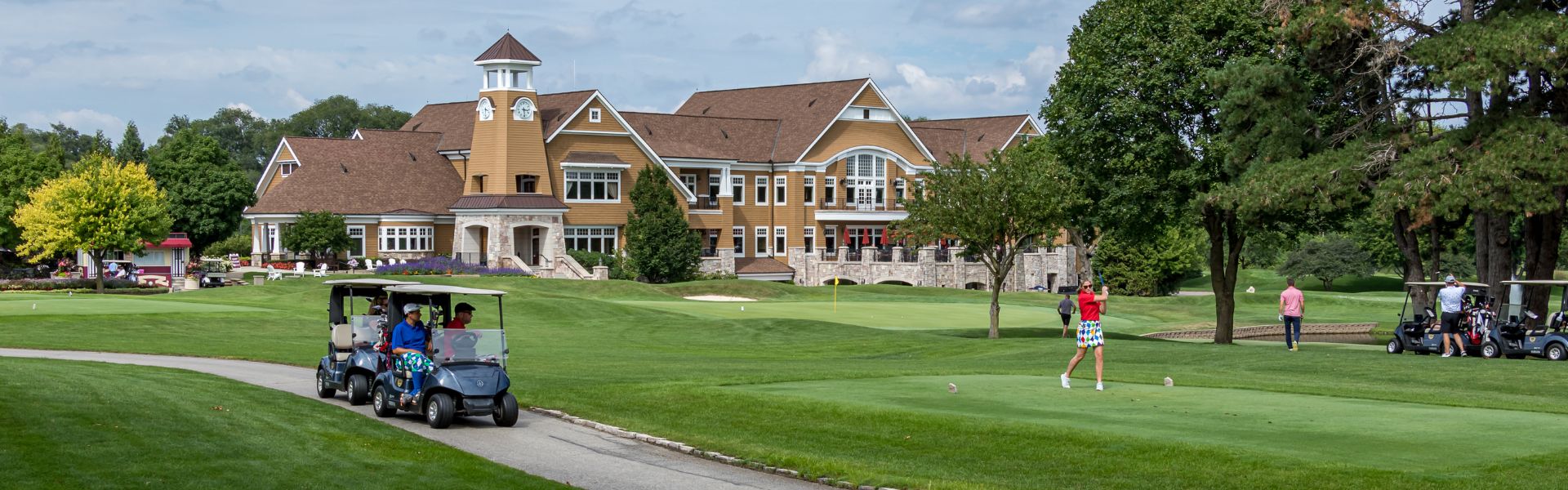 Golfers putting and driving golf cart at the golf course